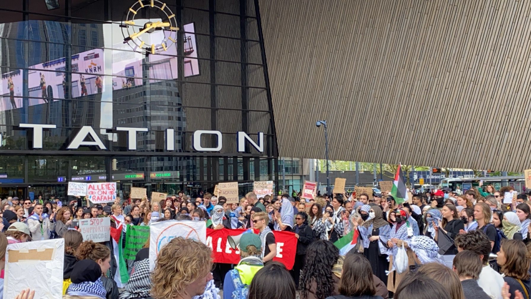 Kleine mensen protesteren tegen de menigte op het plein voor Rotterdam Centraal Station