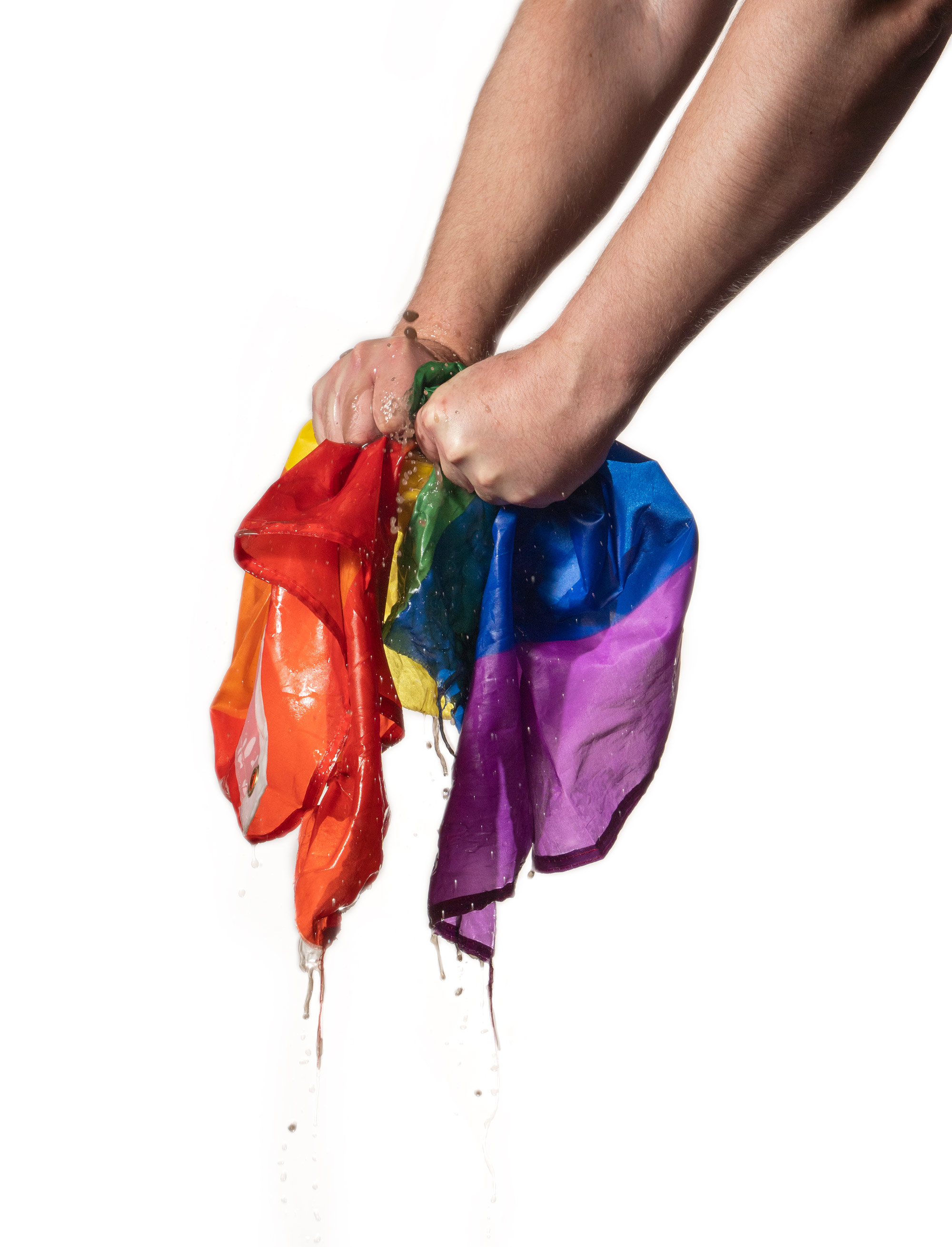 Handen die een natte LGBTQTA+ vlag uitknijpt