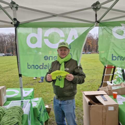 Sjoerd van Vliet met groene AOb-muts en -sjaal op het Malieveld