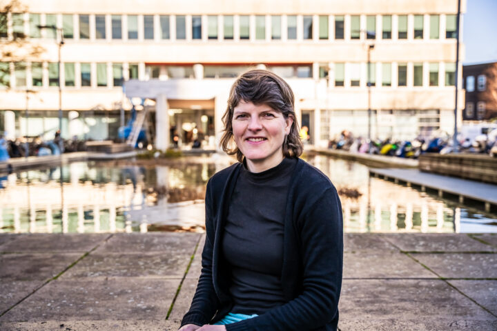 Foto van Sofie die buiten zit bij de vijver voor hogeschoollocatie Museumpark hooggebouw.