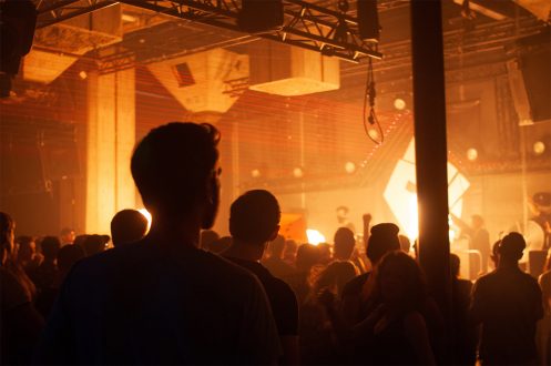 Foto van een ravende menigte in oranje licht