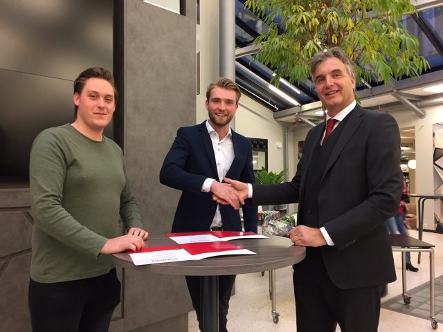Kevin (links) en Bart ontvangen het erkenningscertificaat van collegebestuurder Wijnand van den Brink