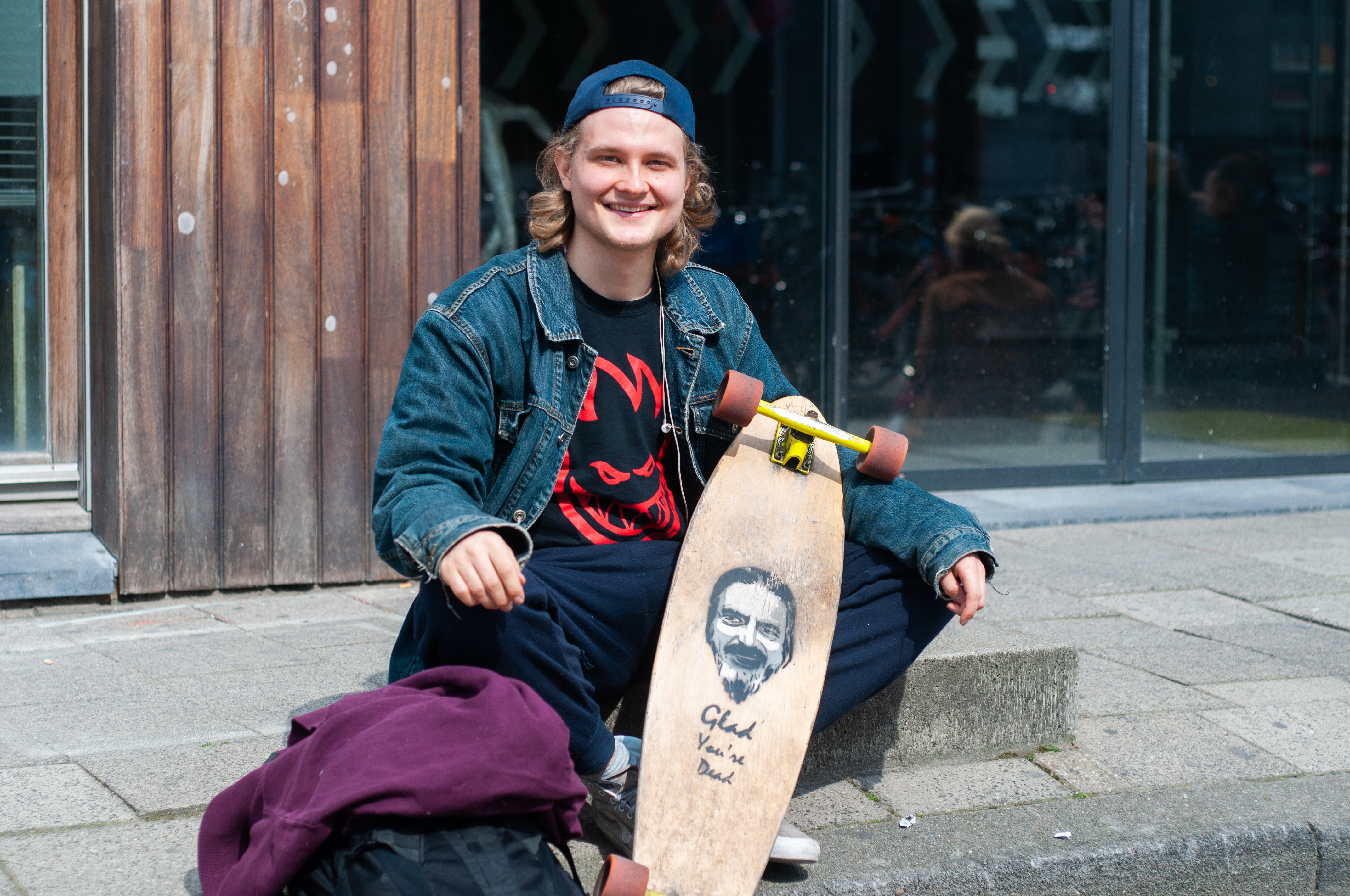 Portret van Berend, zittend op de stoep met zijn skateboard