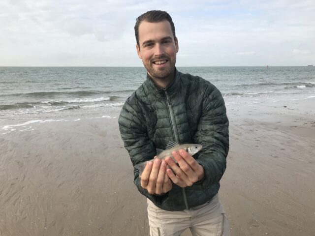 Foto van Rein Smeets op het strand met een visje in zijn handen