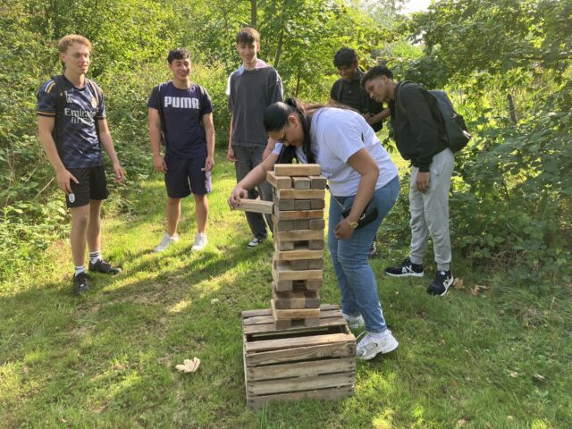 Student tek een steen uit de Jenga-stapel