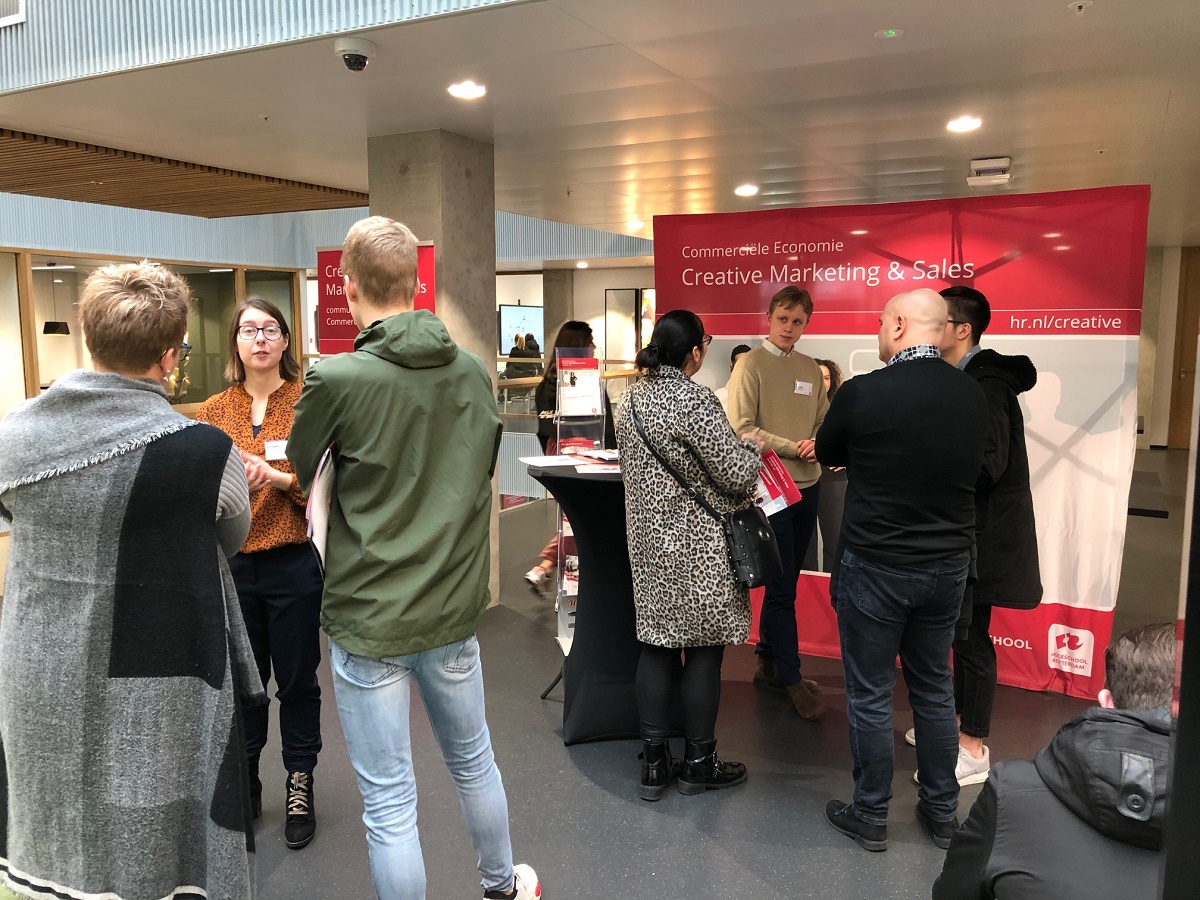 Studente geven voorlichting bij de stand van creative marketing & sales