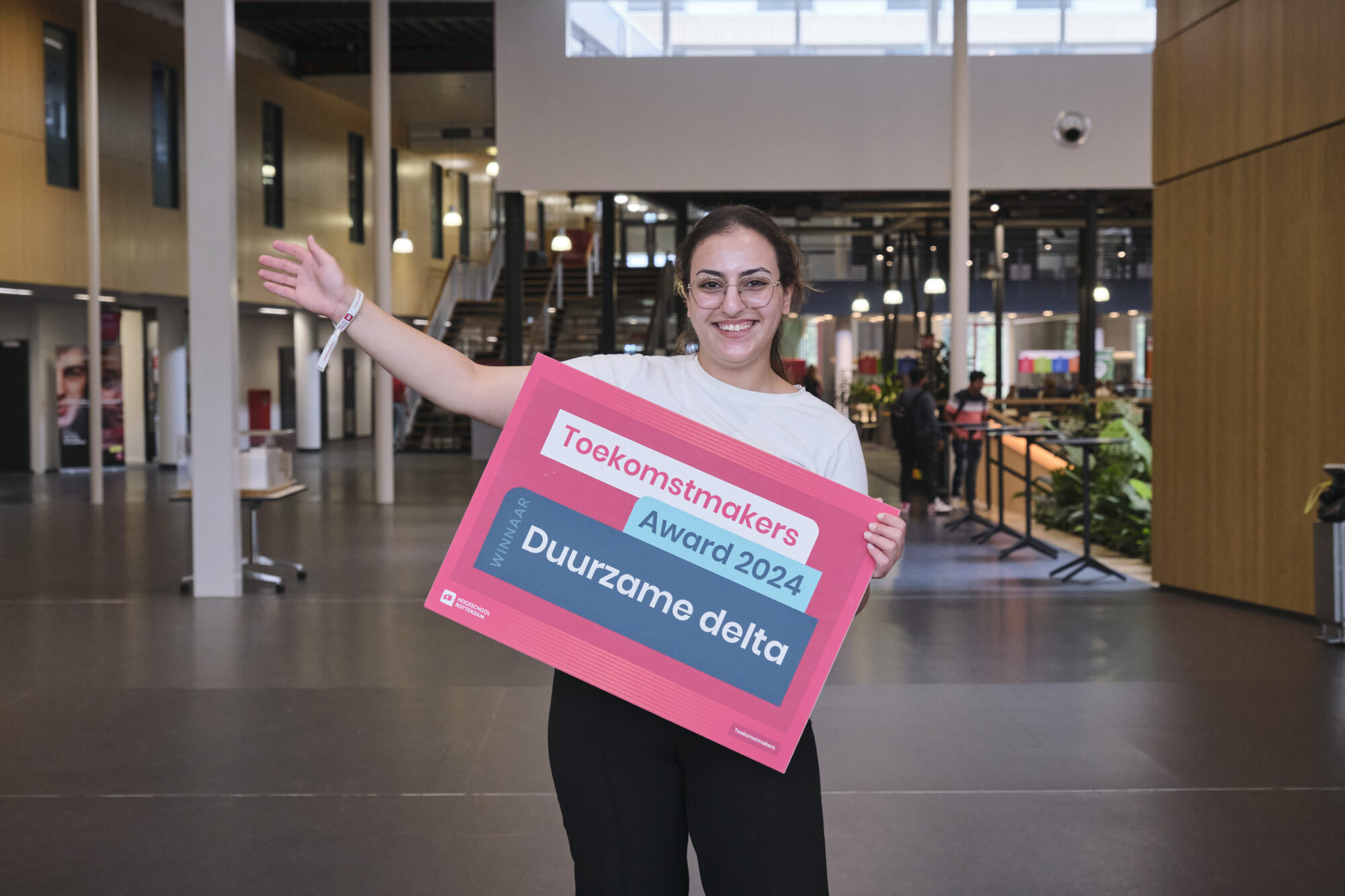 Farida Maai met een bord waarop staat dat ze een Toekomstmakers award heeft gewonnen