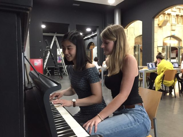 Twee studenten achter een piano