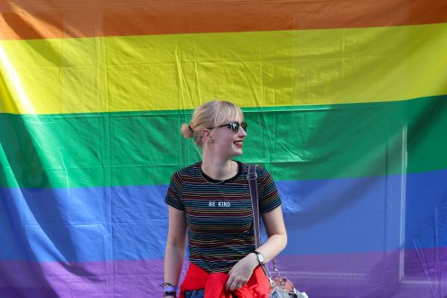 Foto van student Myrthe voor een enorme regenboogvlag