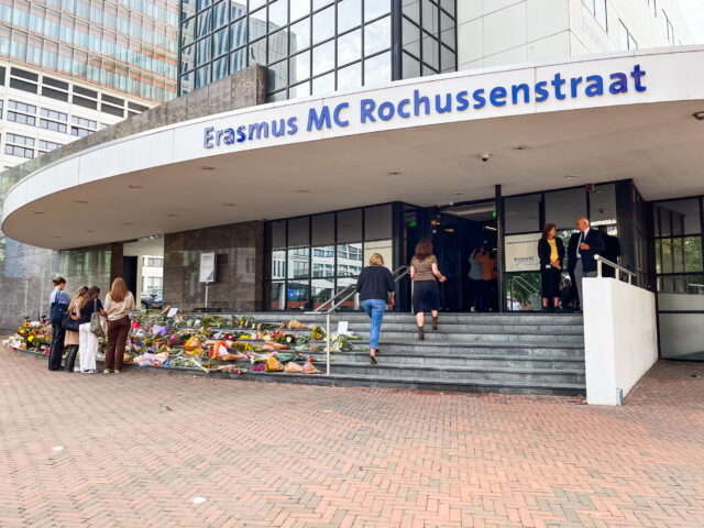 Foto van Erasmuc MC Rochussenstraat met zee van bloemen op de trappen en mensen die erbij staan