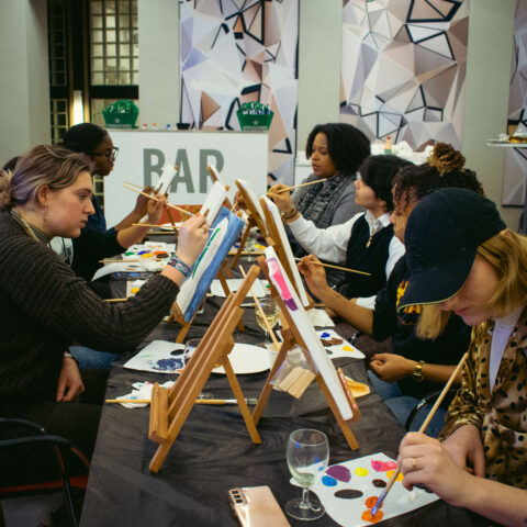 studenten aan het schilderen, met schildersezeltjes op lange tafels