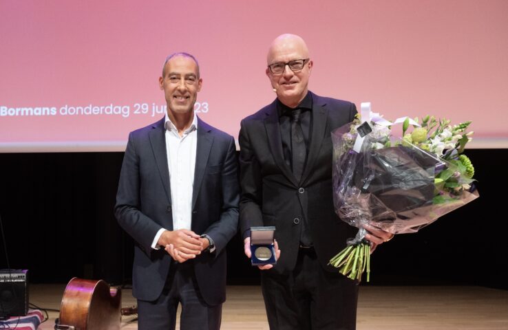 Wethouder Kasmi en Ron Bormans, die bloemen in zijn hand heeft en de wolfert van Borselen Penning