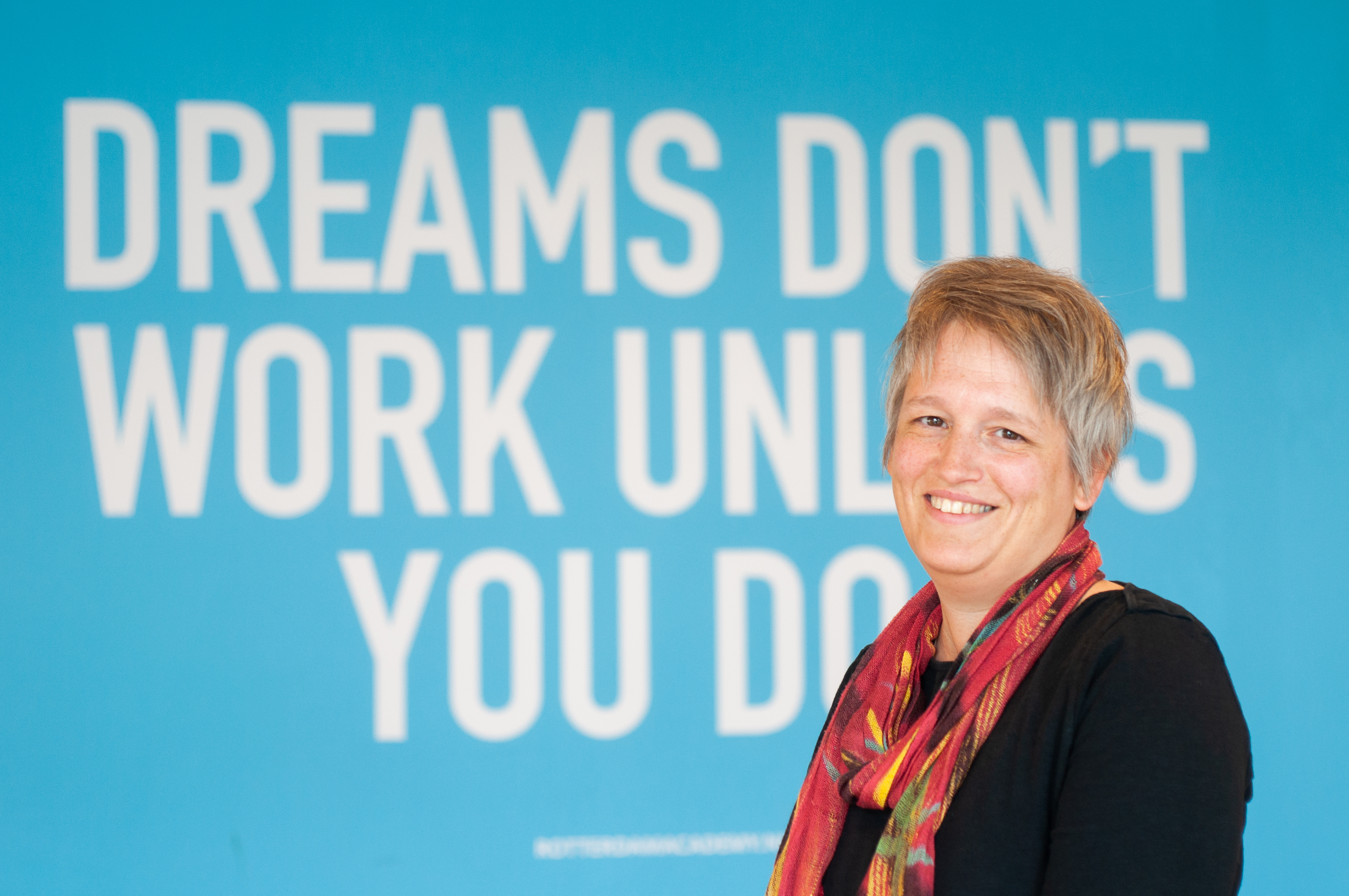 Portret van Rosalie de Klerk voor een muur waarop staat: Dreams don't work unless you do.