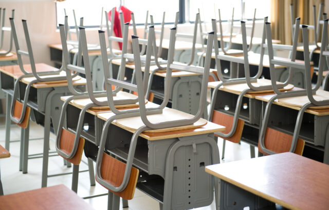 Lege klas met opgestapelde stoelen